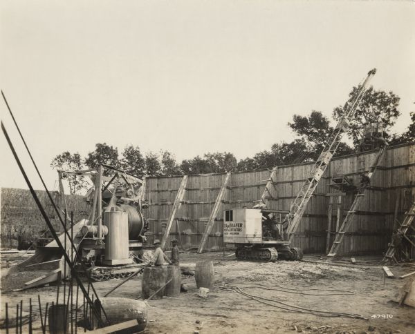 A building site with "O'Dea and Shafer, Engineers and Contractors" construction crew, crane and other equipment. On the photograph album binding on the left side of the photograph is written "Reservoir at Madison."