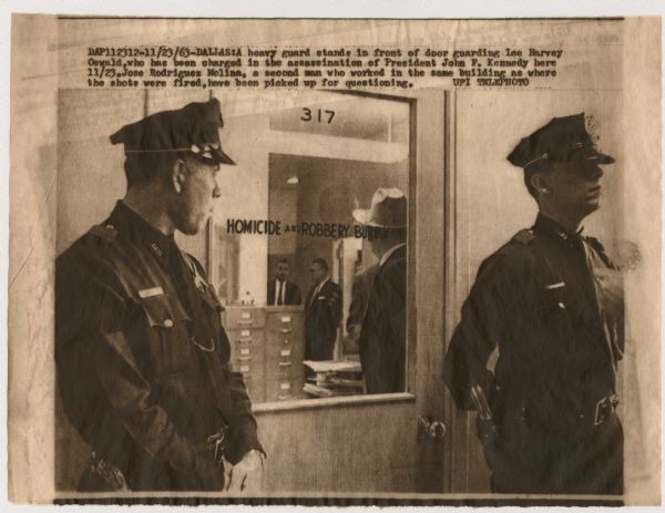 Original UPI Wirephoto transmission. Caption reads: "A heavy guard stands in front of door guarding Lee Harvey Oswald, who has been charged in the assassination of President John F. Kennedy here 11/23. Jose Rodriguez Molina, a second man who worked in the same building as where the shots were fired, have been picked up for questioning."