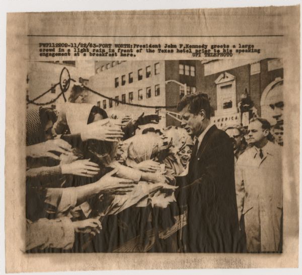Original UPI Wirephoto transmission. Caption reads: "President John F. Kennedy greets a large crowd in a light rain in front of the Texas hotel prior to his speaking engagement at a breakfast here."