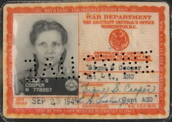 The identification card of Signe S. (Skott) Cooper, 1st Lt., ANC. (First Lieutenant, Army Nurse Corps.) The card was issued SEP 25 1945. Her photograph is on the left, name and signatures on the right. When the card is reversed, the punched holes across the ID spell "INACTIVE."