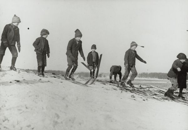 Winter scene with boys on skis preparing to compete at the first ski tournament in Stoughton, Wisconsin, possibly in ski jumping.