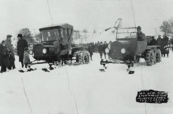 Winter scene of early snowmobile race at Rangeline Lake. Bill Neu (right), winner, Harold Hansen (left). Special conversion kits were available which allowed skis to be mounted on front wheel spindles, and an endless belt arrangement mounted on rear wheels. In the background is a crowd, and in the far background is what may be a wooden structure for ski jumping on top of a hill. In the lower right is the text: "Wm Neu. Winner Snowmobile Race. Winter-Sports. Three Lakes, Wis."