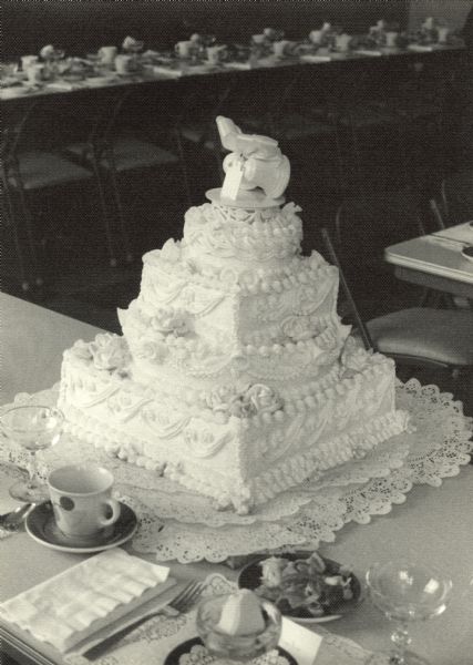 Wedding cake with topper of two bells and a bow at the wedding reception of Mary (Kustermann) Esser (b. 1934) and J. Thomas Esser (b. 1934).