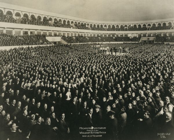 The Ad Wolgast-Willie Ritchie boxing match in the Milwaukee Auditorium. There were 8,000 people in attendance. Most of the audience members have turned to face the camera.