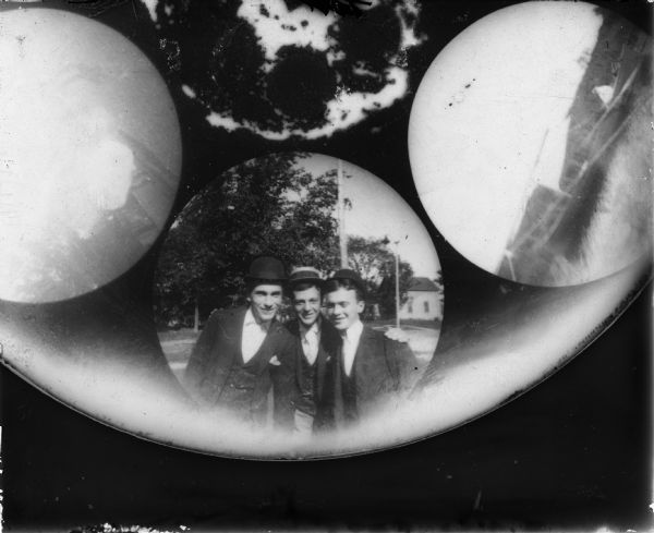 An image of three men taken with a Stirn Concealed Vest Pocket Camera. The #1 Detective Camera held a 14cm round glass plate for making six 4cm wide round exposures. The camera could be hidden in a vest pocket and the lens peeked through the button hole. This led to the popular name "buttonhole camera." They were also called a detective camera, spy camera and vest pocket camera.