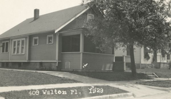 Photographic postcard view from street of the house at 409 Walton Place. Built by Willard Droster. Caption reads: "409 Walton Pl. 1929."