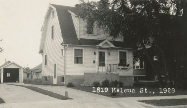 Photographic postcard view from street of the house at 1819 Helena Street, and the garage behind it on the left, both built by Willard Droster. Caption reads: "1819 Helena St., 1929."
