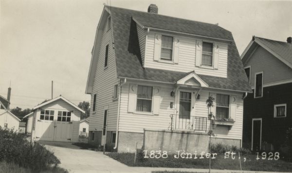 Photographic postcard view from street of the house at 1838 Jenifer Street, and the garage behind it on the left, both built by Willard Droster. Caption reads: "1838 Jenifer St., 1928."