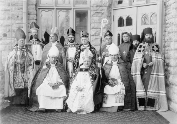 Consecration of Bishop Weller as Bishop Coadjutor, Diocese of Fund du Lac. Three Bishops seated, l to r: Bishop Nicholson of Milwaukee; Bishop Grafton of Fund du Lac; Bishop Anderson, Coadjutor of Chicago. Standing, l to r: Bishop Kozlowski of Polish National Church; Bishop Williams of Marquette; Bishop Weller; Bishop Francis of Indianapolis; Bishop McLaren of Chicago; Bishop Williams, Coadjutor of Nebraska; Father Kochuroff, Chaplain to Russian Bishop; Father Sebastian, Chaplain to Russian Bishop; and Bishop Tikhon of Alaska and the Aleutian Islands. They are dressed in religious vestments.