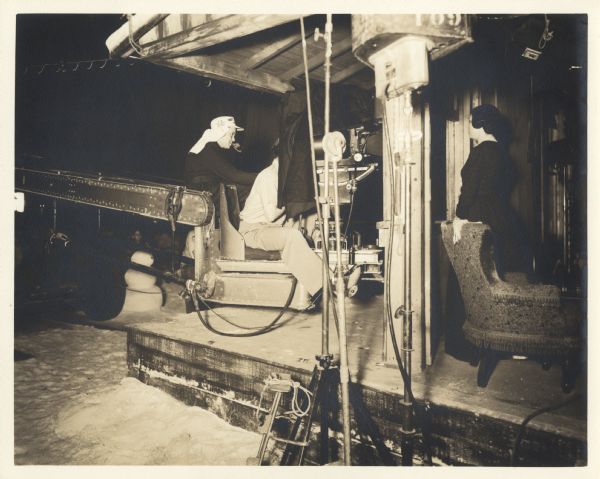 Orson Welles directs Agnes Moorehead in a scene from the film <i>Citizen Kane</i>. Welles is sitting on the camera crane behind the camera operator. The camera is shooting Moorehead through a window on the set.