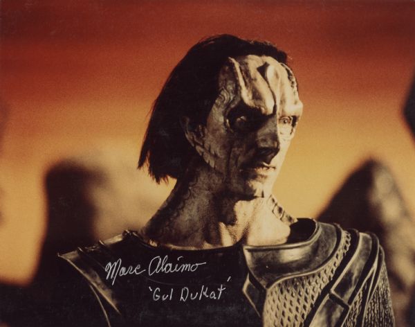 Quarter-length color portrait of Marc Alaimo in full makeup as his character 'Gul Dukat' from the TV series <i>Star Trek: Deep Space Nine</i>. Autographed at bottom left.
