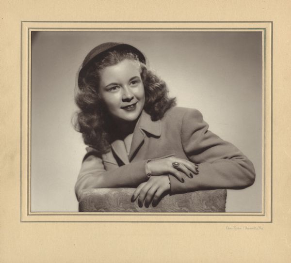The formal, quarter-length studio portrait of Margaret McGuire that was judged along with her resume for the first Alice in Dairyland contest. She became 1 of 16 finalists before winning the competition. She is posing with her elbows resting on the back of a chair, and is wearing a coat, hat with veil, and a ring.<p>The photograph ran in the Dodgeville Chronicle on May 20, 1948, in an advertisement for OBMA Studios. The text reads: "Our photograph of Miss McGuire was selected by the judges as one of the 4 best in the entire state of Wisconsin. We are highly gratified that this honor has come to Miss McGuire whose photograph was competing with others from the best studios in the state."</p>