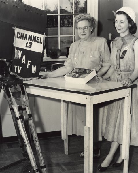 Margaret McGuire, the 1948 Alice in Dairyland, on WAFM-TV, Channel 13, with another woman promoting Wisconsin Cheese.