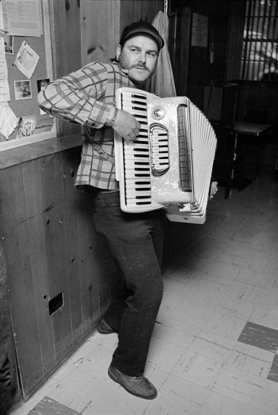 An accordion player standing and playing at a book signing party at the Club Tavern for E.E. LeMasters, author of the book, <i>Blue-Collar Aristocrats</i>.