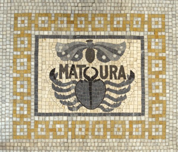 Mosaic in the north/central lobby floor of the Wisconsin Historical Society. This is the printer's mark for Jehan Frellon, a prominent printer in Lyons, France from 1540 to 1550. Features a crab and moth motif, and the word "Matura."