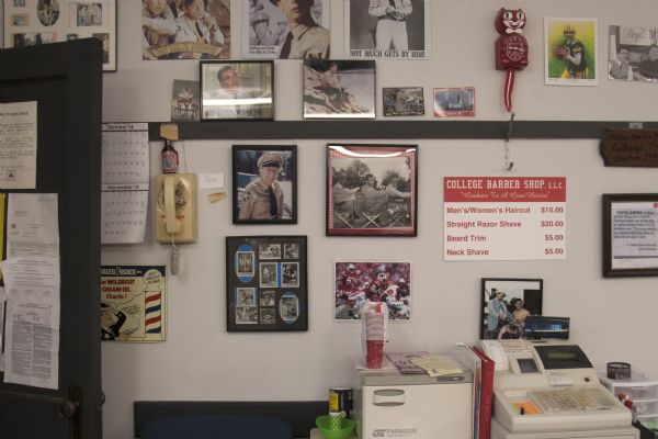 The last week of business at the College Barber Shop. Interior details include prices for haircuts, shaves, and trims, and framed photographs and other items displayed on the wall.