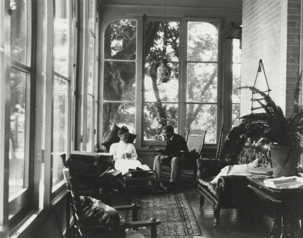 A man and women relaxing on the porch at Villa Louis.