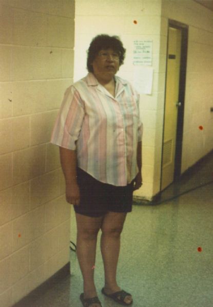 Beverly Oustigoff standing in the hall of the school where she works as a teacher's aid.
