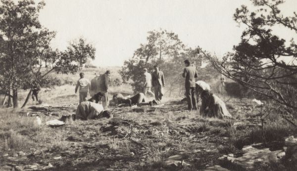 A group of people playing a game at Taliesin. Some of them are kneeling on the ground.