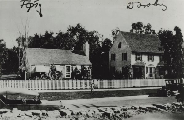 Jackson Turner Main standing in front of "Chimney Corners" holding a butterfly net. He is the grandson of Frederick Jackson Turner, University of Wisconsin American History professor. "Chimney Corners" was F.J. Turner's retirement cottage located on Van Hise Avenue.