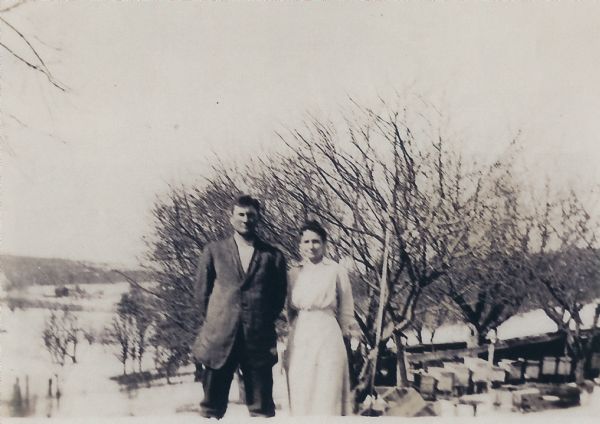Vogt and Louise "Lulu" Schildgen posing in front of an orchard. Their son's name was Raymond Schildgen.