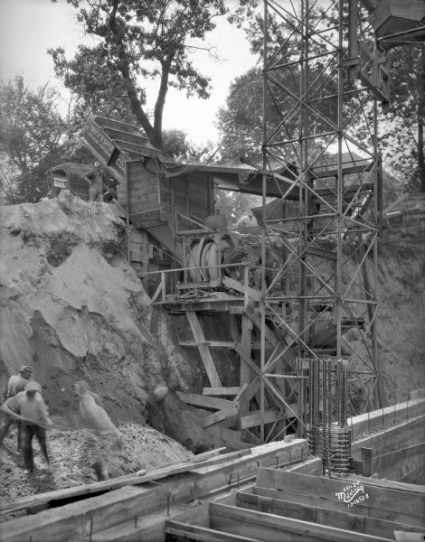 State Office Building, Wilson Street, construction showing concrete mixer, workers, and a Castle & Doyle truck dumping.