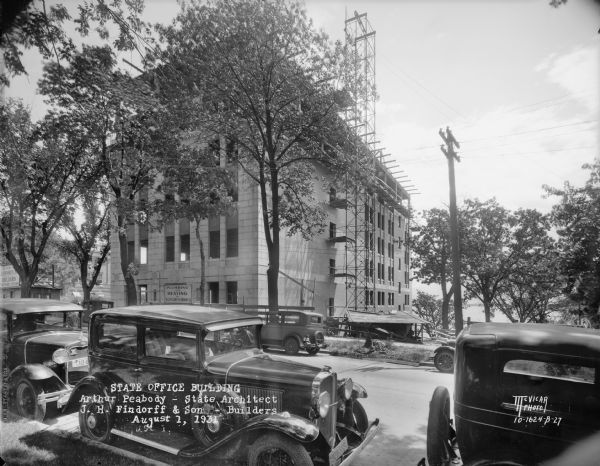 State Office Building, 1 W. Wilson Street, under construction. View from the right on Wilson Street with automobiles in foreground.
