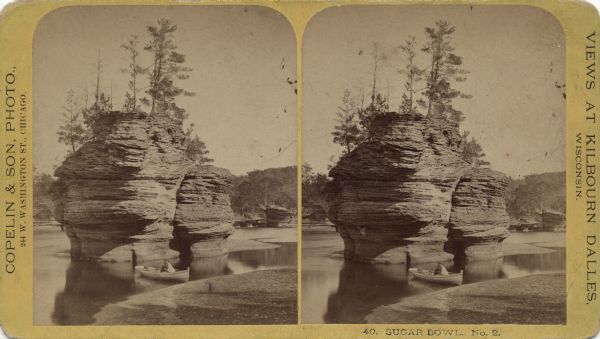 Stereograph of the Sugar Bowl, a rock formation in the Wisconsin Dells, with trees growing on the top. A man in a rowboat is floating between the rock and the beach the foreground. In the background is the far shoreline with more rock formations. Caption on front reads: "40. Sugar Bowl. No. 2" and "View at Kilbourn Dalles, Wisconsin." Text handwritten on reverse reads: "This view shows a specimen of our rocks in some of our rivers — They are not quite as hard as your Granite — being soft — the water wears them away, giving them some queer shapes. VV."