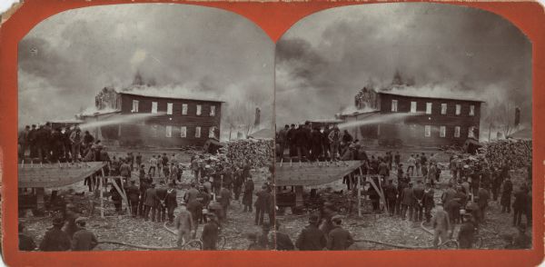 Stereograph of a fire at the Choate-Hollister Furniture Company. A crowd, mostly men, are gathered to watch the effort to extinguish the fire. On the left, men are standing on a partially finished structure to get a better view. The company was headed by Leander Choate and Seymour Hollister, who had a controlling interest in the company by 1895. They never reopened after the fire of 1899. The fire also spread past Jackson Street to the east and destroyed the Star Foundry & Machine Works; Hayward Carriage Company; Charles Repe's Stone Cutting Works; and Gusavus & Hintze Boiler Works. 
