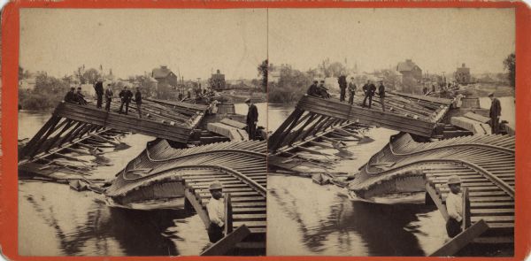 Stereograph of a demolished railroad bridge, most likely over the Rock River. Several men are standing on a horizontal section. In the bottom right corner, a young man is gazing towards the camera. On the far shore, more people are standing in a group, observing. In the background is the city of Beloit. Hand-written on the reverse: "C. & N.W.R.R. Bridge after Cyclone, looking South. Beloit, Wis. No. 12."