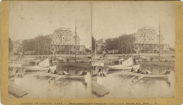 Stereograph view of the Whiting House with its large harbor and boats. Whiting House is a four-story wood frame Second Empire style hotel standing on the lake shore at Lake Geneva. Several sets of stairs are leading to a porch which extends across the front of the first floor. Several rowboats and sailboats are moored in front of the hotel. Horse-drawn vehicles are parked on the shore. Many people can be seen standing on land or aboard the boats. In the foreground, four people are sitting in a rowboat, and three are rowing, with person sitting in the stern. Other buildings of the village are on the left.