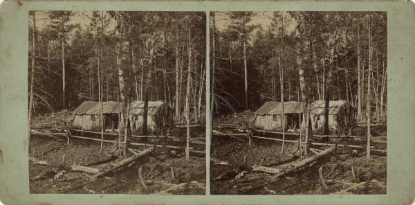 Stereograph of a boarding house in the woods surrounded by a pole fence. Hand-written on the reverse: "First Boarding house of Florence, Erected March 1st, 1880."