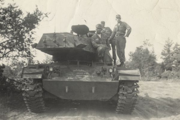 Lewis Arms (sitting in front on the left) and two other soldiers posing on a tank at Fort McCoy.