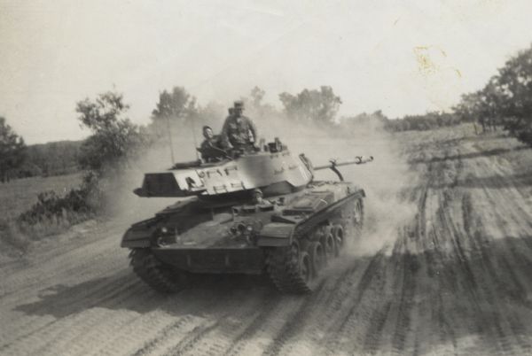 Several soldiers (possibly including Lewis Arms) riding along a tank trail in a tank at Fort McCoy.
