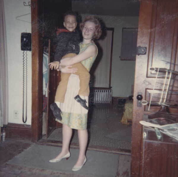 Janet Sauk holding Paul Arms in the home of Lewis Arms at 847 Williamson Street.