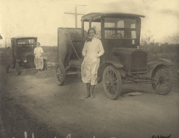 Women drivers of light dump trucks for the highway department in Ashland County during the first World War. The truck in the foreground has a service flag with two stars below the right side of the windshield, indicating that the family has two service members serving in the war.