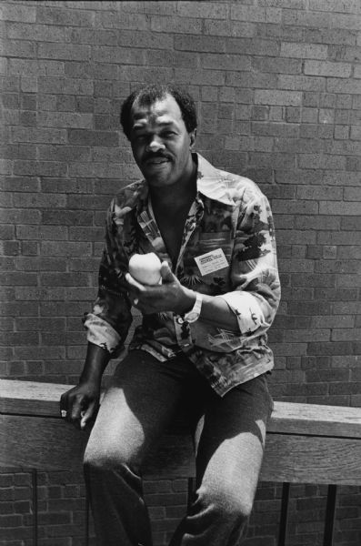 Casual portrait of Councilman Marion Barry of Washington, D.C., sitting on a railing, eating an apple. He was attending the Conference on Alternative State and Local Public Policies held on the St. Edward's University Campus. In 1979 and 1995 he became the 2nd and 4th Mayors of Washington, D.C.
