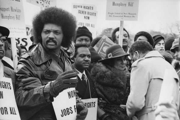 The Reverend Jesse Jackson, Delegate Walter E. Fauntroy and Representative Bella Abzug at a PUSH (People United to Serve Humanity) March supporting the proposed Humphrey-Hawkins Equal Employment Bill. Protest signs worn and held by the demonstrators read: "Silver Rights Now, Jobs for All, Support Hawkins-Humphrey Bill." 