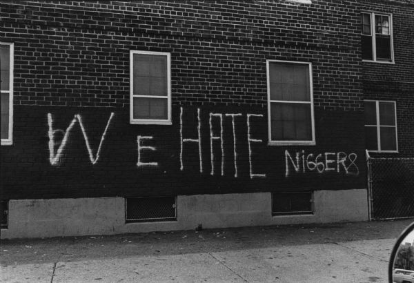 Racist graffiti spray painted on the wall of a South Boston housing project. It reads: "We HATE Niggers." This image was captured during the unrest following court-ordered school desegregation busing.