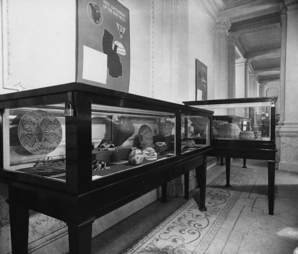 An exhibit of baskets which were probably created by American Indians in Wisconsin. A sign on the wall above the display case reads: "Seed Gatherers of the Far West."