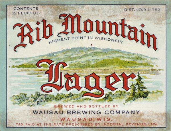 Label submitted to the state of Wisconsin for trademark registration. "Rib Mountain Lager, Highest Point in Wisconsin, Brewed and Bottled by Wausau Brewing Company." Pictured on the label is an image of rib Mountain with a flag at the top. In the foreground of the label is a body of water, most likely Lake Wausau.