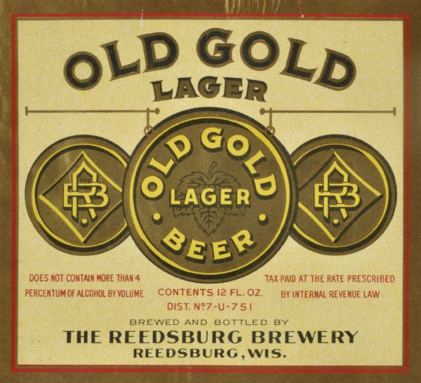 Label submitted to the state of Wisconsin for trademark registration. "Old Gold Lager, Old Gold Lager Beer, Brewed and Bottled by the Reedsburg Brewery." The gold, yellow and red label features three circles, two with the Reedsburg Brewery logo with the letters "RB" flanking a larger circle with "Gold Lager Beer" printed over what appears to be a hop leaf in the middle.