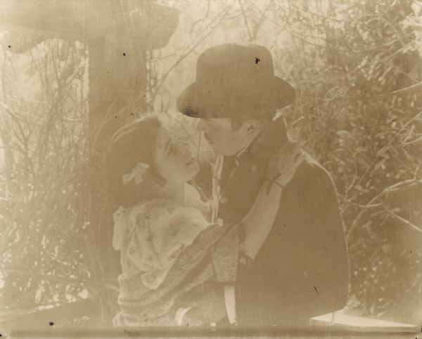 Film still of a man and woman, exterior.


