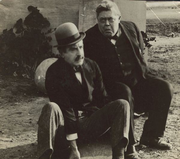 Film still - exterior with two men sitting. 


	