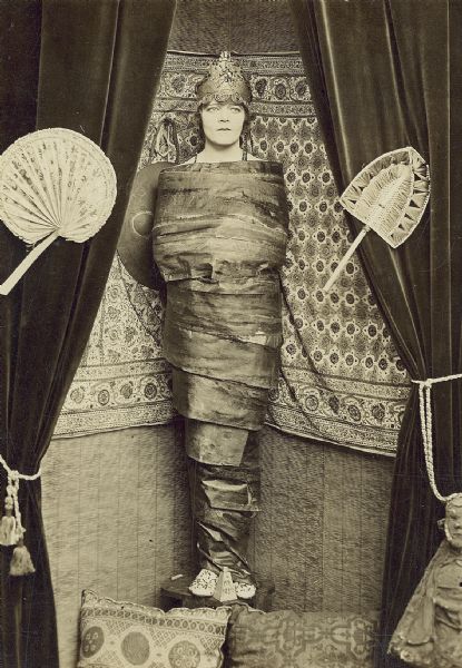 Film still - interior - actress wrapped as a mummy.