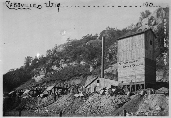 The Chicago, Burlington and Quincy Railroad stone crusher. There is a large group of workmen posing along the work site.