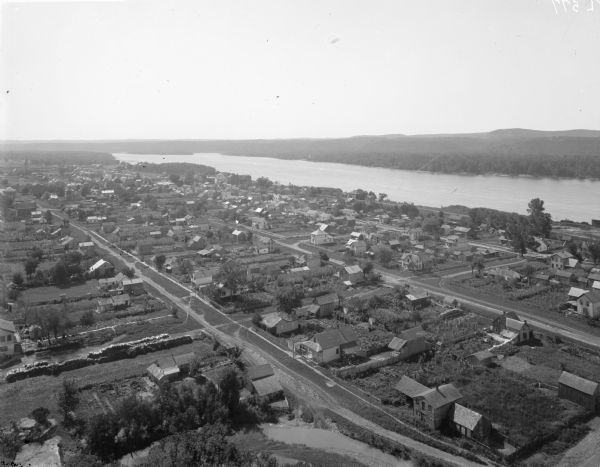 Aerial view of town. The Mississippi River and far shoreline is in the background. The Furnace Branch creek runs through the town in the foreground.