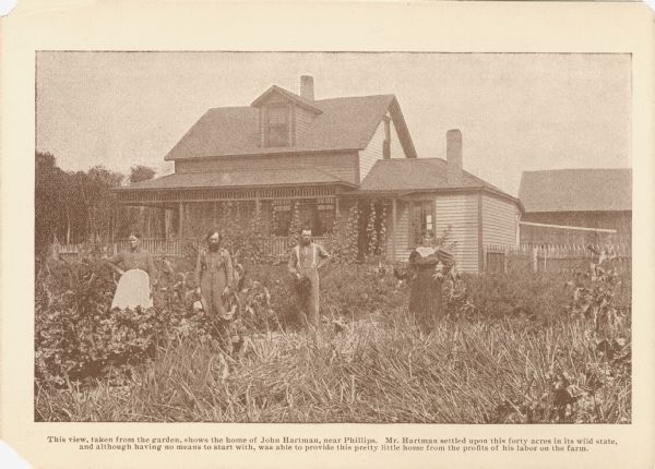 Two men and two women pose outside the home of John Hartman. The caption reads, "This view, taken from the garden, shows the home of John Hartman, near Phillips. Mr. Hartman settled upon this forty acres In its wild state, and although having no means to start with, was able to provide this pretty little home from the profits of his labor on the farm."