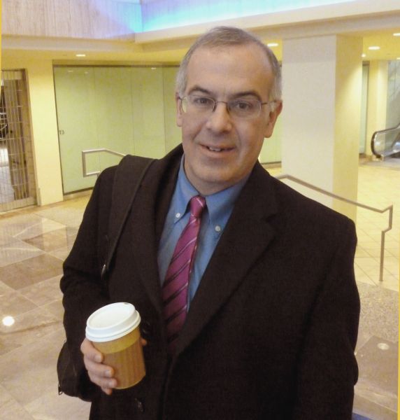 Snapshot of "New York Times" columnist David Brooks, holding a cup of coffee, at the National Press Club Building.