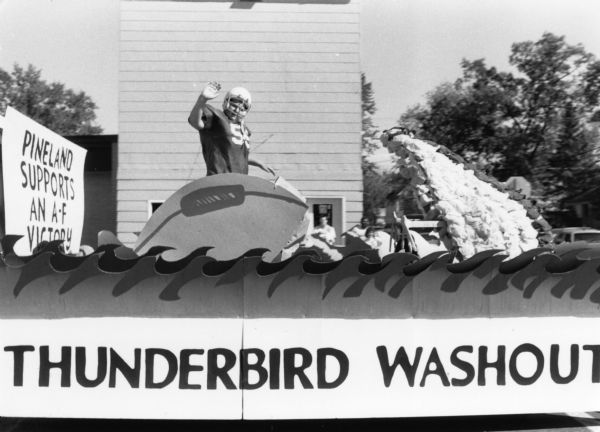 The “Thunderbird Washout” float at the Adams-Friendship High School homecoming parade. On the float, a boy in football attire is waving to the crowd.